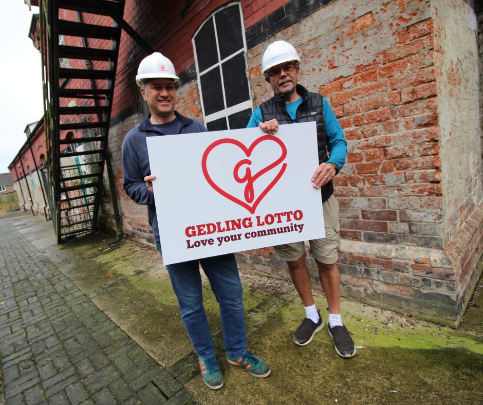 Chair of the Gedling Youth and Community Hub, Francis Rodrigues and Volunteer Project Manager, Andy Owens outside Hub with Gedling Lotto logo